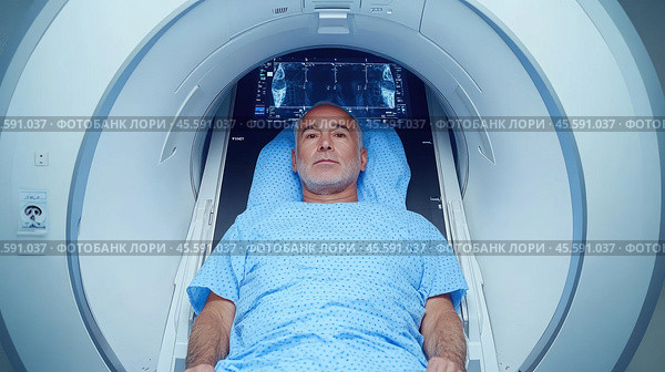 A middle-aged man lies inside an MRI machine. Стоковое AI-изображение, AI-художник Александр Довянский / Фотобанк Лори