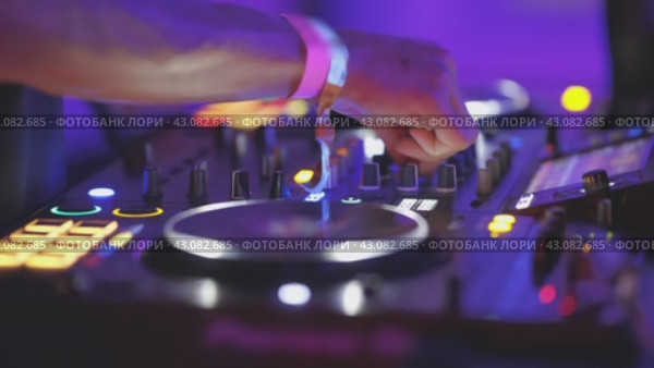 A person is playing a DJ set with a purple background. Стоковое видео, видеограф Константин Шишкин / Фотобанк Лори