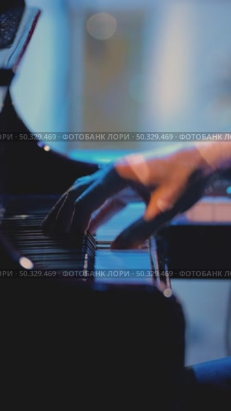 A pianist with one hand playing gentle classical music on a grand piano in slow motion. Close-up of piano keys in dark colors. Стоковое видео, видеограф Воловодов Владимир / Фотобанк Лори