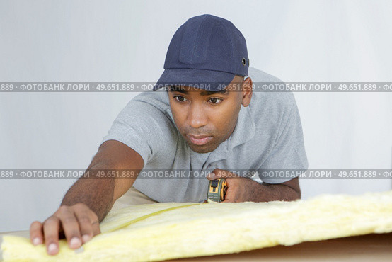 a plasterer measuring a padding. Стоковое фото, агентство Ingram Publishing / Фотобанк Лори