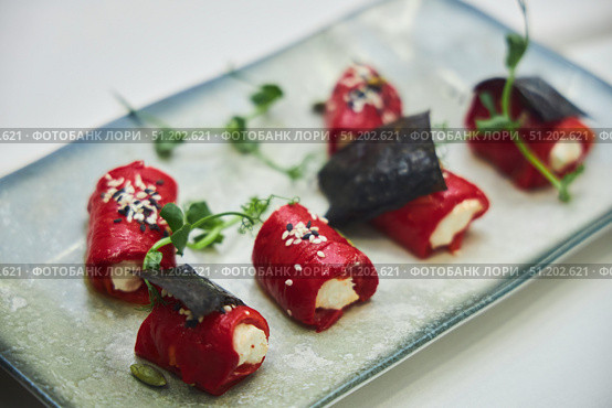 A plate of food with a variety of vegetables and a garnish of black seaweed. The dish is presented on a white plate and is arranged in a visually appealing manner. Стоковое фото, фотограф Наталия Кирсанова / Фотобанк Лори