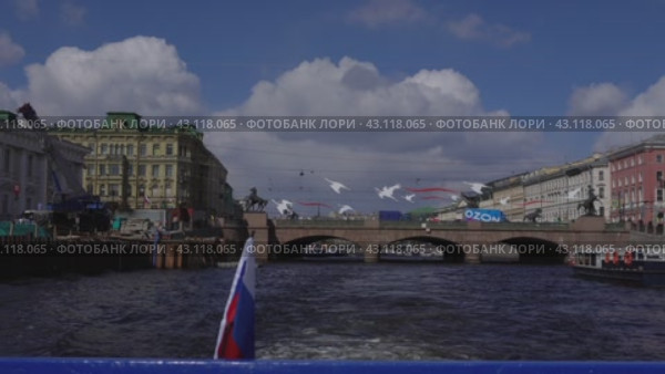 A pleasure excursion boat passes along the Fontanka River opposite the Anichkov Bridge on the Fontanka River. View from the stern against the background of the Russian tricolor. Russia. St. Petersburg. 05/08/2024. Редакционное видео, видеограф Ярославский Максим / Фотобанк Лори