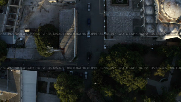 a red car drives slowly down a narrow street. Стоковое видео, видеограф Aleksandr Sulimov / Фотобанк Лори