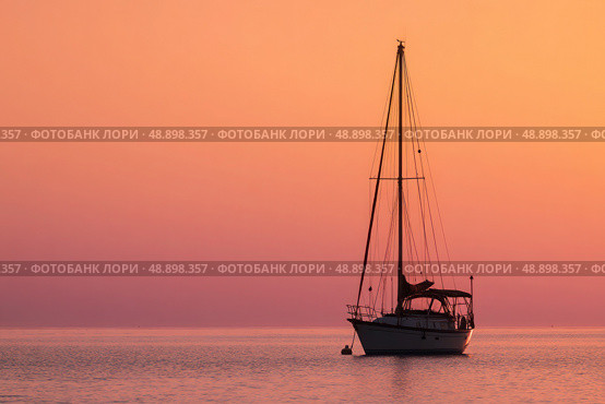 A sailboat is floating in the ocean at sunset. Стоковое AI-изображение, AI-художник Ярославский Максим / Фотобанк Лори
