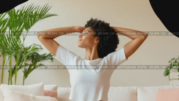 A serene woman with rich curly hair stretching arms upward in a peaceful indoor setting, embracing a moment of tranquil comfort. Стоковое AI-видео, аниматор Данила Большаков / Фотобанк Лори