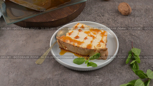 A single, tempting slice of caramelized molotov pudding, drizzled with sweet caramel and garnished with fresh mint leaves, ready to be enjoyed on a small plate with a spoon. Стоковое фото, агентство Ingram Publishing / Фотобанк Лори