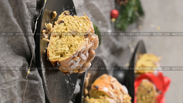 A slice of Bolo Rainha, a traditional Portuguese sweet bread, dusted with powdered sugar and adorned with almonds and cashews. Стоковое фото, агентство Ingram Publishing / Фотобанк Лори