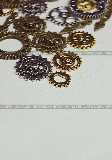 A steampunk and ancient macro about machinery made of bronze, silver and gold gears with beige background. Стоковое фото, агентство Ingram Publishing / Фотобанк Лори