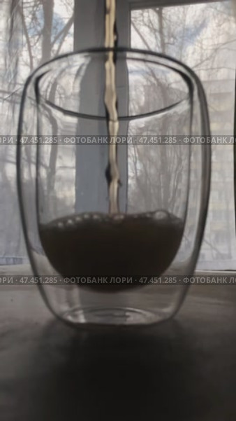A stream of yellow foaming drink falls into a clear glass tumbler. Стоковое AI-видео, аниматор Ярославский Максим / Фотобанк Лори