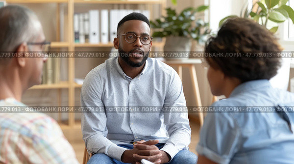A therapist listens intently in a counseling session with a couple seeking guidance, seated in a cozy, sunlit room. Стоковое AI-изображение, AI-художник Данила Большаков / Фотобанк Лори