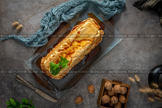 A top-down view showcases a whole molotof, a traditional caramelized egg white pudding, generously drizzled with sweet syrup and garnished with fresh mint on a glass platter. Стоковое фото, агентство Ingram Publishing / Фотобанк Лори