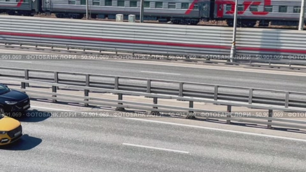 A train with the letters D and F on it is on a track next to a highway. Редакционное видео, видеограф Ярославский Максим / Фотобанк Лори