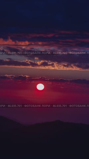 A vertical sunset video over the sea, filmed high in the mountains, with a pink and purple skyline. Вертикальное видео заката над морем, снятое высоко в горах, с розовым и фиолетовым горизонтом. Стоковое видео, видеограф Валерий Тесаков / Фотобанк Лори