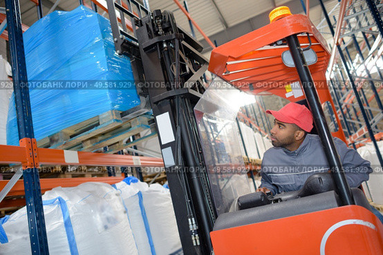 a warehouse worker driving forklift. Стоковое фото, агентство Ingram Publishing / Фотобанк Лори