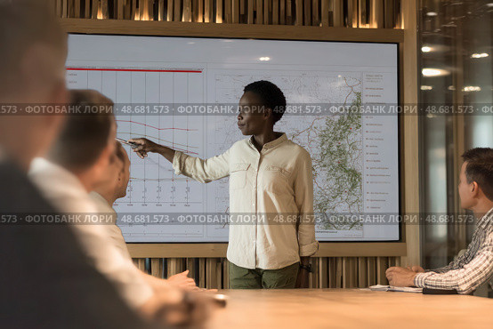 A woman is giving a presentation in front of a large screen. Стоковое AI-изображение, AI-художник Ярославский Максим / Фотобанк Лори