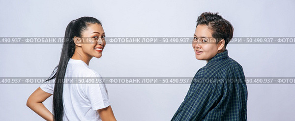 A woman of two lovers stood hand in hand and looked back and turned. Стоковое фото, агентство Ingram Publishing / Фотобанк Лори