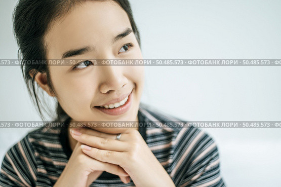 A woman sat with his hands rested under the chin and smiled happily. Стоковое фото, агентство Ingram Publishing / Фотобанк Лори