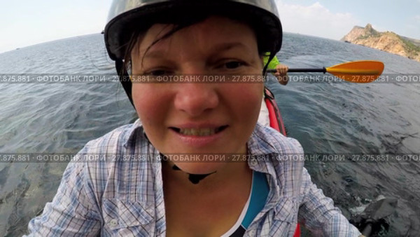 A woman swims into the sea in a kayak by directing herself to the camera. Стоковое видео, видеограф Tatiana Kravchenko / Фотобанк Лори