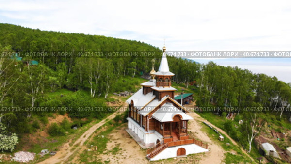A wooden church on a mountain on the shore of Lake Baikal. Church of the Transfiguration of the Lord. Baikal village. Деревянная церковь на горе на берегу озера Байкал. Церковь Преображения Господня. Стоковое видео, видеограф Виктория Тельминова / Фотобанк Лори