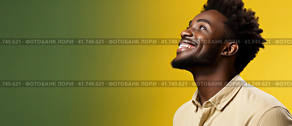 A young African man in a T-shirt on a uniform background looks up and smiles. Generated by AI. Стоковое AI-изображение, AI-художник Ярославский Максим / Фотобанк Лори
