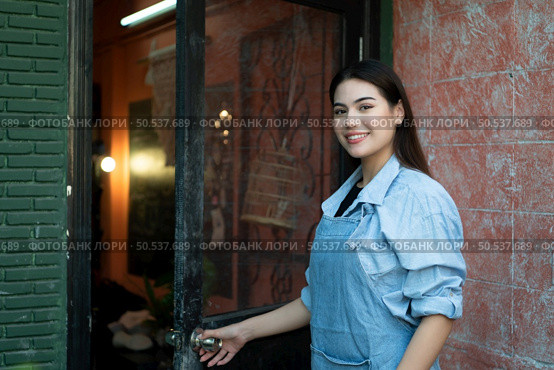 A young businesswoman who owns a pottery school Open the door to welcome students who love to learn pottery. Стоковое фото, агентство Ingram Publishing / Фотобанк Лори