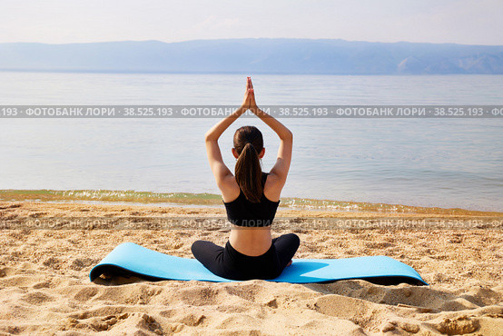A young girl is doing yoga on a sandy beach. Meditation and rest. Стоковое фото, фотограф Виктория Тельминова / Фотобанк Лори