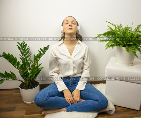 A young girl, sitting on the floor with headphones, closing her eyes. Стоковое фото, фотограф Anna Scherbina / Фотобанк Лори
