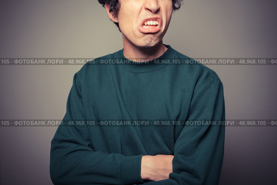 A young man is gesturing and pulling silly faces. Стоковое фото, агентство Ingram Publishing / Фотобанк Лори