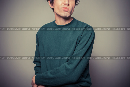 A young man is gesturing and pulling silly faces. Стоковое фото, агентство Ingram Publishing / Фотобанк Лори