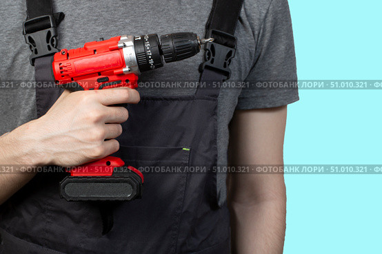 A young man with a screwdriver for construction work. Insulate. Стоковое фото, фотограф Александр Поташев / Фотобанк Лори