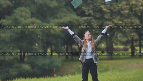 A young schoolgirl tosses up her notebooks in the books. Стоковое видео, видеограф Mikhail Davidovich / Фотобанк Лори