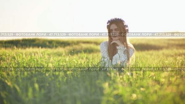 A young Ukrainian girl poses in a young wheat field. Стоковое видео, видеограф Mikhail Davidovich / Фотобанк Лори