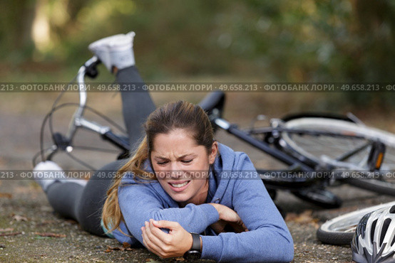 a young woman fell off a bicycle and is suffering. Стоковое фото, агентство Ingram Publishing / Фотобанк Лори