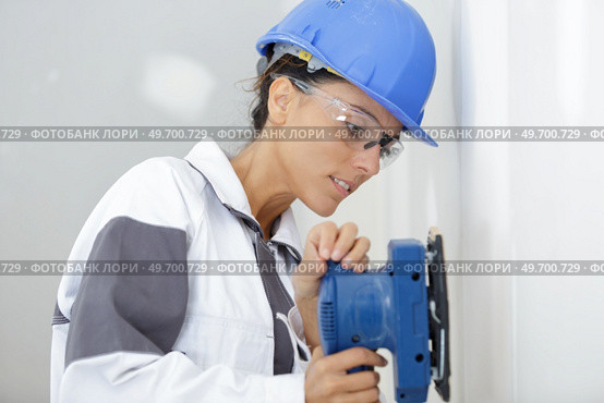 a young woman sanding wall. Стоковое фото, агентство Ingram Publishing / Фотобанк Лори