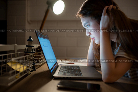 A young woman works on her laptop at home. It is characterized with headaches that occur when stressed. Стоковое фото, агентство Ingram Publishing / Фотобанк Лори