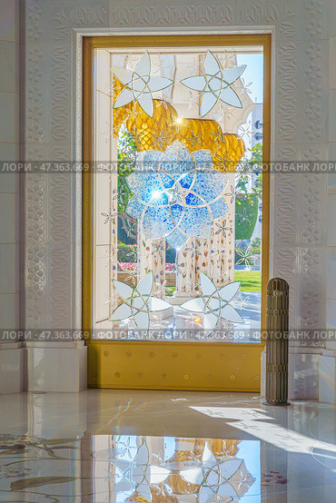 Abu Dhabi, United Arab Emirates - Jan 10 2024, A view of door with stained glass window with a floral pattern, in the Grand Mosque of Sheikh Zayed, at daytime Abu Dhabi, United Arab Emirates. Редакционное фото, фотограф Сергей Богомяко / Фотобанк Лори