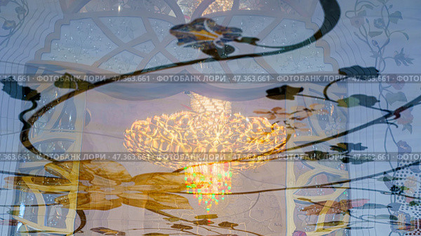 Abu Dhabi, United Arab Emirates - Jan 10 2024, View of giant chandelier inlaid with Swarovski crystals in reflection on marble floor the Grand Mosque of Sheikh Zayed Abu Dhabi, United Arab Emirates. Редакционное фото, фотограф Сергей Богомяко / Фотобанк Лори