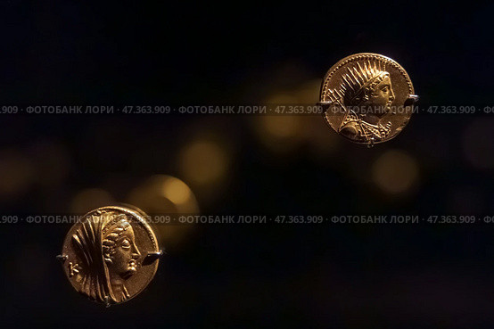Abu Dhabi, United Arab Emirates - Jan 17 2024, Close-up view of the ancient antique coins in the Louvre Abu Dhabi Museum, belonging to different eras, Abu Dhabi, United Arab Emirates. Редакционное фото, фотограф Сергей Богомяко / Фотобанк Лори