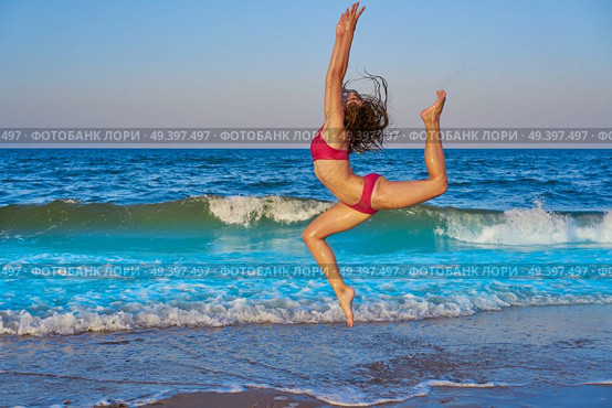 acrobatic gymnastics bikini girl in a beach blue shore at summer. Стоковое фото, агентство Ingram Publishing / Фотобанк Лори