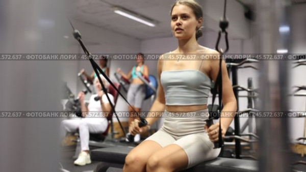 Active athlete young woman during exercises on crossover exercise machine with loops and weighting. Стоковое видео, видеограф Яков Филимонов / Фотобанк Лори