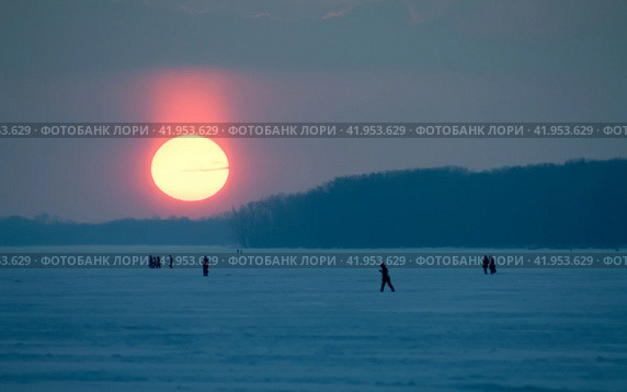 active people walk along the embankment of the Volga river and on frozen ice on a winter evening (2011 год). Стоковое фото, фотограф Акиньшин Владимир / Фотобанк Лори