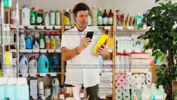 Adult man scanning qr code for floor and wood cleaner. Стоковое видео, видеограф Яков Филимонов / Фотобанк Лори