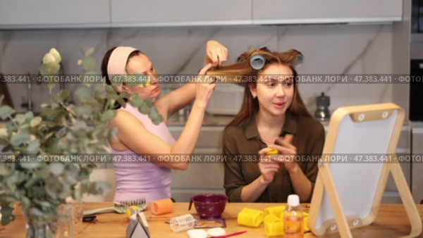Adult woman curls hair of young woman. Стоковое видео, видеограф Яков Филимонов / Фотобанк Лори