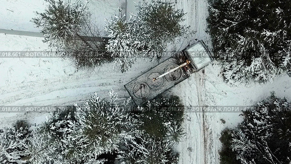 Aerial top view of a crane truck trying to turn around on narrow winter road. Стоковое фото, фотограф David Kashakhi / Фотобанк Лори