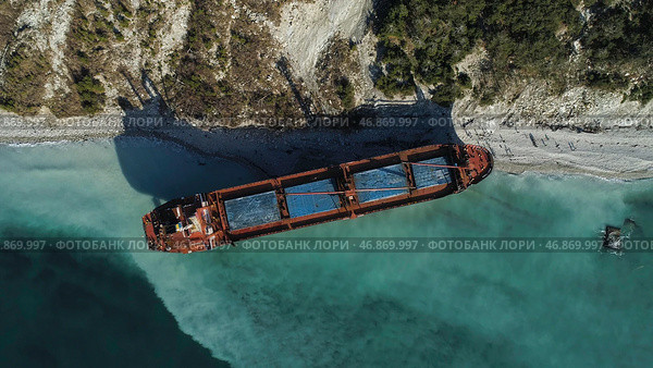 Aerial top view of an empty, red barge moored near the beautiful blue sea shore. Стоковое фото, фотограф David Kashakhi / Фотобанк Лори