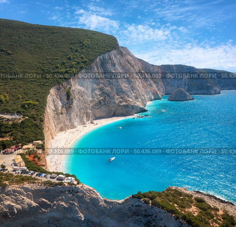 Aerial view of blue sea, rock, sandy beach at sunset in summer. Famous Porto Katsiki, Lefkada island, Greece. Beautiful landscape with sea coast, azure water, sky, clouds. Top view of shore. Travel. Стоковое фото, агентство Ingram Publishing / Фотобанк Лори