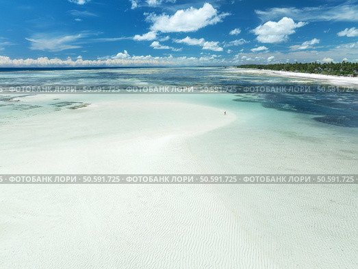 Aerial view of island during low tide, sandbank in ocean, white sandy beach, people, blue sea on sunny summer day in Zanzibar. Top view of sand spit, clear water, sky with clouds. Tropical resort. Стоковое фото, агентство Ingram Publishing / Фотобанк Лори