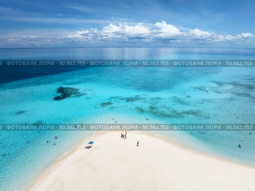 Aerial view of Nakupenda island, sandbank in ocean, white sandy beach, blue sea in low tide at sunny summer day in Zanzibar. Top view of sand spit, clear azure water, people, sky with clouds. Tropical. Стоковое фото, агентство Ingram Publishing / Фотобанк Лори