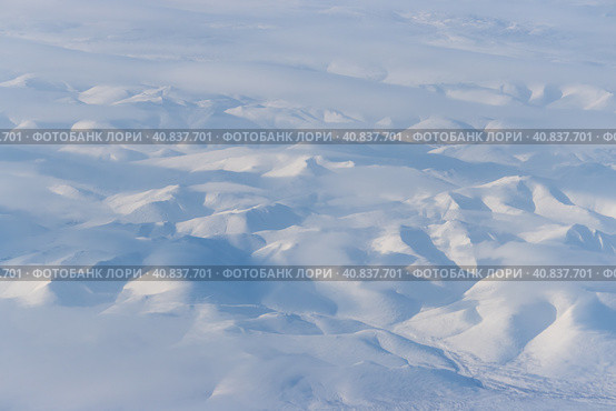 Aerial view of snow-capped mountains and clouds. Winter snowy mountain landscape. Icheghem Range, Kolyma Mountains. Koryak Okrug (Koryakia), Kamchatka Krai, Siberia, Far East Russia. Great background. Стоковое фото, фотограф Андрей Степанов / Фотобанк Лори