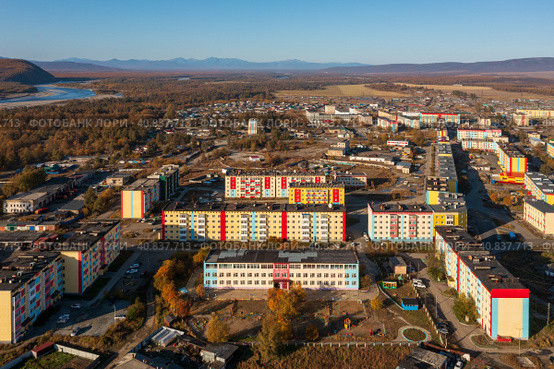 Aerial view of the northern urban-type settlement of Ola. Top view of painted multi-colored buildings. Ola is the administrative center of the Olsky district of the Magadan region. Siberia, Russia. Стоковое фото, фотограф Андрей Степанов / Фотобанк Лори